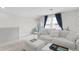 Spacious living area with a plush white couch and two ottomans at 5519 Blue Crush Bnd, Land O Lakes, FL 34638