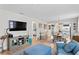 Living room with comfortable blue couch, large TV, and access to dining area at 5519 Blue Crush Bnd, Land O Lakes, FL 34638