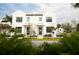 Two-story modern white house with dark gray doors and landscaping at 5980 Central Ave, New Port Richey, FL 34653