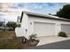 White two-car garage with modern lighting and landscaping at 5980 Central Ave, New Port Richey, FL 34653