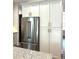 Stainless steel refrigerator with white cabinetry and granite countertops at 5980 Central Ave, New Port Richey, FL 34653