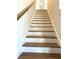Elegant staircase with wooden steps and a wooden handrail at 5980 Central Ave, New Port Richey, FL 34653