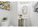 A half bathroom with a pedestal sink, an oval mirror, and a gray storage cabinet at 6324 Camino Dr, Apollo Beach, FL 33572