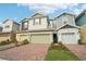A welcoming townhome exterior showcases a brick driveway with an attached garage and green landscaping at 6324 Camino Dr, Apollo Beach, FL 33572