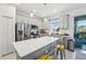 Modern kitchen with stainless steel appliances, center island with seating, and a view to the outdoor patio at 6324 Camino Dr, Apollo Beach, FL 33572