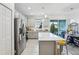 Well-lit kitchen showcasing stainless steel appliances, a large island, and sliding door access to the outside at 6324 Camino Dr, Apollo Beach, FL 33572