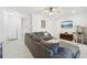 Spacious living room featuring a large gray sectional, tile flooring, and a modern ceiling fan at 6324 Camino Dr, Apollo Beach, FL 33572