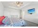 A bright main bedroom with a ceiling fan, tray ceiling, and a view of the ensuite bathroom at 6324 Camino Dr, Apollo Beach, FL 33572