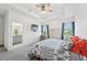 A bright main bedroom with a ceiling fan, tray ceiling, large windows, and an ensuite bathroom at 6324 Camino Dr, Apollo Beach, FL 33572