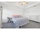 A bright main bedroom with a ceiling fan, tray ceiling, gray carpet, and white trim at 6324 Camino Dr, Apollo Beach, FL 33572