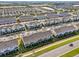 Expansive aerial shot of a neighborhood showcasing rows of modern townhouses, neatly planned streets, and community landscaping at 6324 Camino Dr, Apollo Beach, FL 33572
