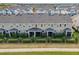 The image displays attractive townhomes, highlighted by neat landscaping and covered outdoor seating at 6324 Camino Dr, Apollo Beach, FL 33572