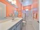 Bathroom with coral walls, white vanity, and shower at 727 Winterside Dr, Apollo Beach, FL 33572