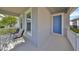 Covered front porch with two chairs and a blue front door at 727 Winterside Dr, Apollo Beach, FL 33572