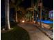 Night view of backyard oasis with pool, fire pit, and lush landscaping at 751 34Th Ne Ave, St Petersburg, FL 33704