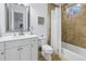 Clean bathroom with white vanity, shower/tub combo, and stone tile at 751 34Th Ne Ave, St Petersburg, FL 33704