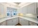 Bright kitchen features white cabinets, granite countertops, and a view at 8001 Sailboat Key S Blvd # 202, St Pete Beach, FL 33707