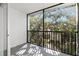 Screened balcony overlooking lush trees and neighboring buildings at 831 Maple Ct # 303, Dunedin, FL 34698