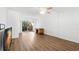 Bright living room with wood-look floors, sliding glass door to balcony, and ceiling fan at 831 Maple Ct # 303, Dunedin, FL 34698
