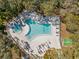 Community pool and hot tub with surrounding lounge chairs at 831 Maple Ct # 303, Dunedin, FL 34698