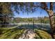 Tennis court with green surface, surrounded by trees and a fence at 978 San Carlos Ne Ct, St Petersburg, FL 33702