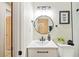 Clean bathroom with a vanity, toilet, and round mirror at 1206 E Osborne Ave, Tampa, FL 33603