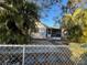 Front view of a house with chain link fence and palm trees at 1308 E Caracas St, Tampa, FL 33603