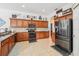 Modern kitchen with dark wood cabinets, granite countertops, and stainless steel appliances at 13317 Blythewood Dr, Spring Hill, FL 34609