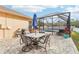 Outdoor patio with table and chairs, adjacent to the pool and screen enclosure at 13317 Blythewood Dr, Spring Hill, FL 34609