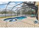 Enclosed pool and spa area with patio and lounge chairs at 13317 Blythewood Dr, Spring Hill, FL 34609