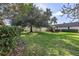 Spacious grassy backyard with mature trees, providing a tranquil outdoor space at 1401 Cordova Grn, Seminole, FL 33777