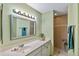 Clean bathroom with single vanity, shower, and light green walls at 1401 Cordova Grn, Seminole, FL 33777