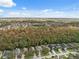 Aerial view of a residential neighborhood with houses, trees, and a pond at 1550 Firewheel Dr, Wesley Chapel, FL 33543