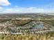 Aerial view of a neighborhood with houses near a pond and surrounding landscape at 1550 Firewheel Dr, Wesley Chapel, FL 33543