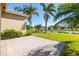 Brick patio, lush landscaping, and peaceful lake view at 15731 Crystal Waters Dr, Wimauma, FL 33598