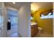 Small half bathroom with wood vanity and yellow walls at 15731 Crystal Waters Dr, Wimauma, FL 33598