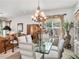 Elegant dining room with glass table and chandelier at 15731 Crystal Waters Dr, Wimauma, FL 33598