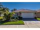 Single-story home with a two-car garage and landscaped front yard at 15731 Crystal Waters Dr, Wimauma, FL 33598