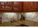 Kitchen detail showing granite countertop and glass-front cabinets at 15731 Crystal Waters Dr, Wimauma, FL 33598
