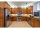 Modern kitchen with stainless steel appliances and wood cabinets at 15731 Crystal Waters Dr, Wimauma, FL 33598