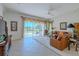 Bright living room with lake view, featuring a comfy leather sectional and tile floors at 15731 Crystal Waters Dr, Wimauma, FL 33598
