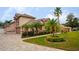 Tan house with palm trees, driveway, and landscaped yard at 1655 Canopy Oaks Blvd, Palm Harbor, FL 34683