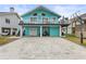 Two-story teal house with a large driveway and a basketball hoop at 17706 1St E St, Redington Shores, FL 33708