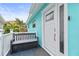 Modern white front door and a gray storage bench at 17706 1St E St, Redington Shores, FL 33708