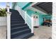 Dark stained wooden stairs leading to the front entrance at 17706 1St E St, Redington Shores, FL 33708