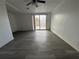 Bright living room with grey vinyl flooring and sliding glass doors at 1833 Knollwood Dr, Holiday, FL 34690