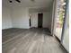 Bright living room featuring gray vinyl plank flooring and sliding glass door to backyard at 1833 Knollwood Dr, Holiday, FL 34690