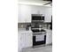Modern kitchen featuring stainless steel appliances, white cabinets, and a designer backsplash at 2912 Star Apple Ct, Palm Harbor, FL 34684