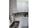 Bright kitchen with stainless steel sink, white cabinets, and a designer backsplash at 2912 Star Apple Ct, Palm Harbor, FL 34684