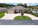 Single-story home with circular driveway, landscaping, and palm trees at 29242 Caddyshack Ln, San Antonio, FL 33576